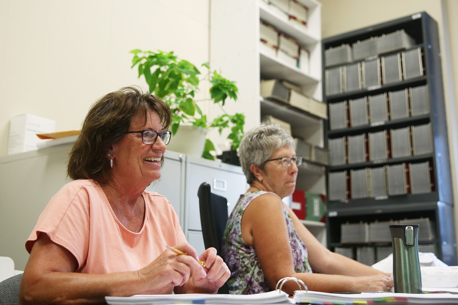 Sheila Camino, left, and Barbara Hartley laugh with coworkers